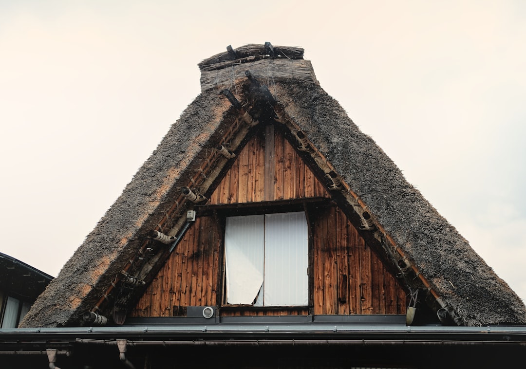 岩手県の積雪地域で屋根の雪下ろしと点検を行っている作業員