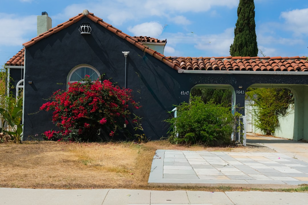 外壁塗装の色見本を持って住宅所有者と相談している業者スタッフ