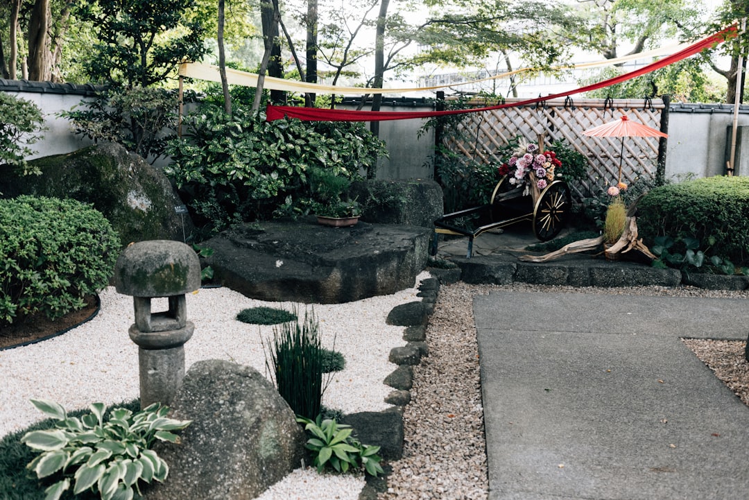 庭師が庭木を丁寧に剪定作業している風景