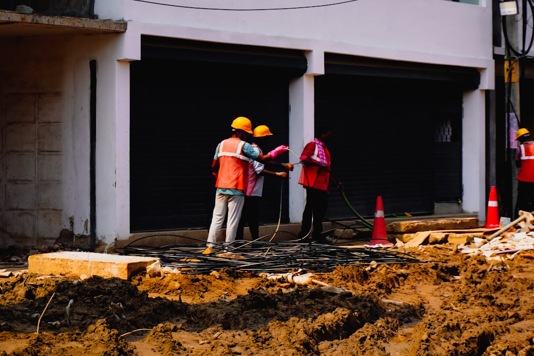 建設現場の工程表を確認する現場監督と作業員の打ち合わせ風景