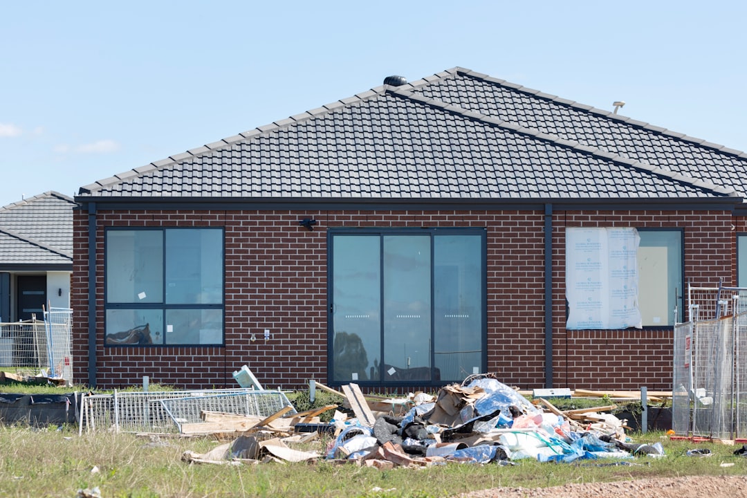 家族4人が新築住宅の前で笑顔でポーズを取る様子