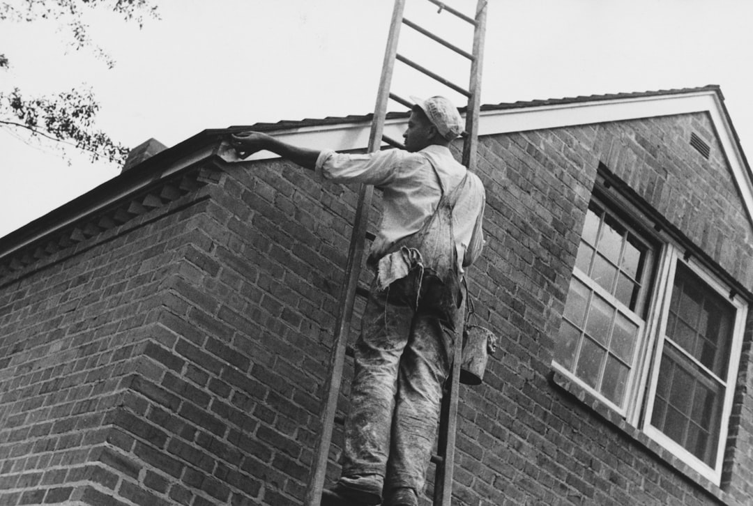 久慈市の住宅街で外壁塗装作業を行う職人の様子
