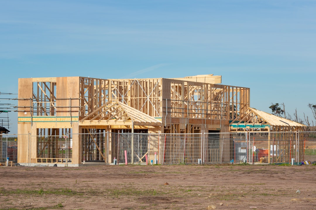 完成した注文住宅の外観と施工業者の看板が写っている様子